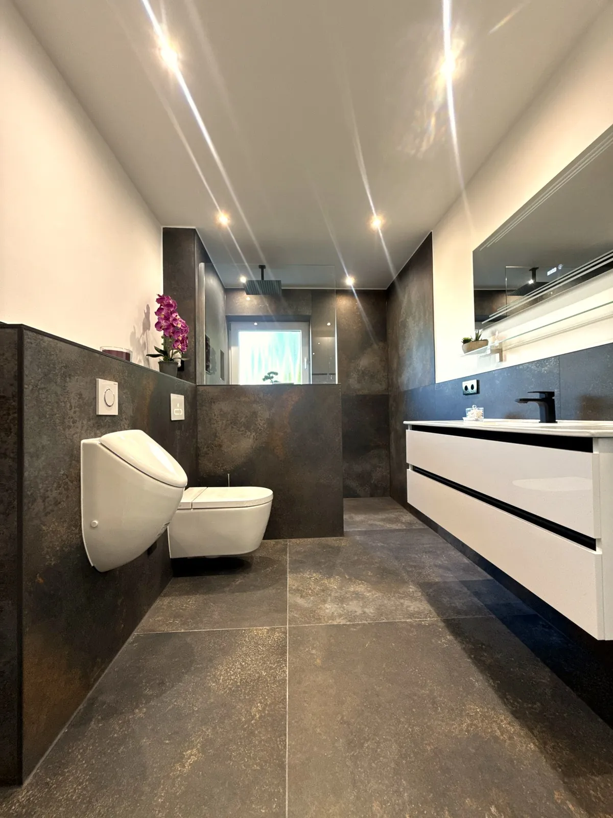 Modernes Bad mit dunklen Großformatfliesen und begehbarer Dusche